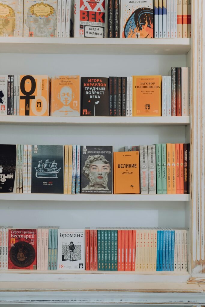 A vibrant collection of books displayed on a decorative white bookshelf.